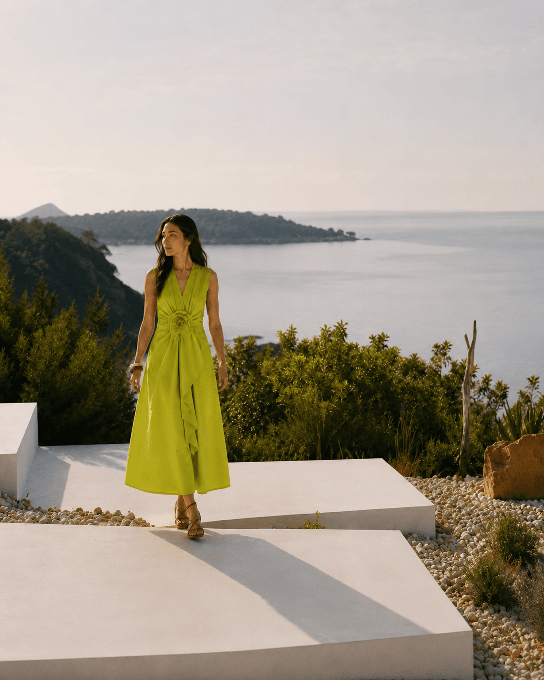 Woman in a chartreuse dress on a coastal terrace